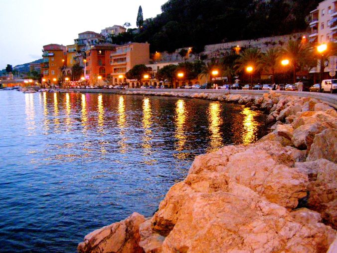 On The Rocks at Villefranche-Sur-Mer. An idyllic location. Not only was the orange light from the lamps reflecting wonderful beams across the water, it was casting an orange glow onto the rocks before me. https://witness.theguardian.com/assignment/552e3c5be4b0dfcbad6c3d9f/1477352